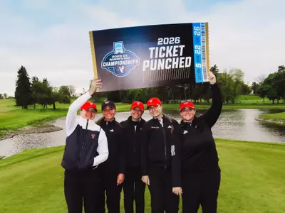Women's golf team posing with "ticket punched" sign at Ann Arbor Regional