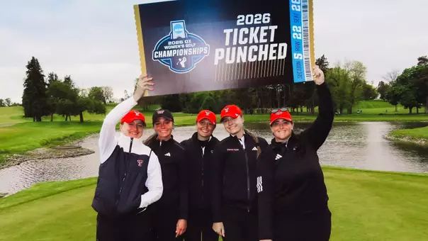Women's golf team posing with "ticket punched" sign at Ann Arbor Regional
