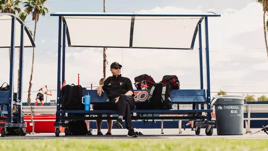 Head Coach Wes Kittley sitting on the Arizona bench as he watches practice