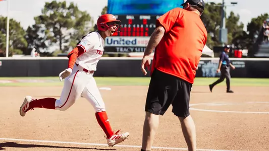 Lauren Allred celebrating and high-fiving Gerry Glasco as she approaches home plate after hitting a grand slam against Ole Miss