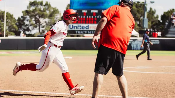 Lauren Allred celebrating and high-fiving Gerry Glasco as she approaches home plate after hitting a grand slam against Ole Miss