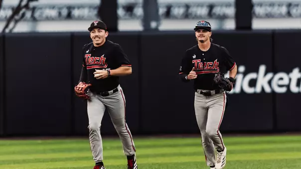 Texas Tech OFers Logan Hughes and Kyeler Thompson run in from the outfielder during Tech's