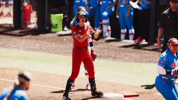 Jackie Lis clapping at first base after driving in a run against Ole Miss