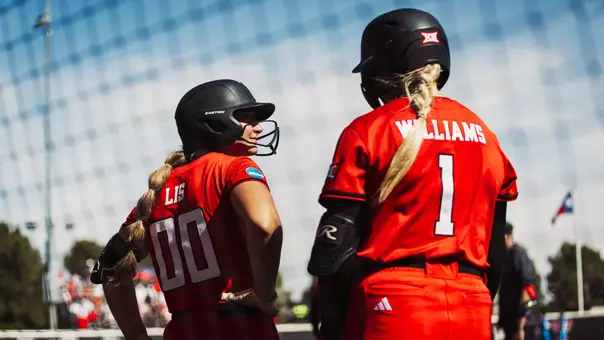 Jackie Lis and Mia Williams in the on deck circle talking before their at-bats