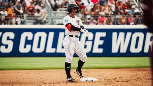 Lauren Allred smiles at second base after a RBI double in Texas Tech's WCWS opener against Mississippi State.