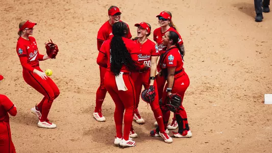 Teammates celebrate with Jackie Lis after she makes a catch to end the third inning against Tennessee.