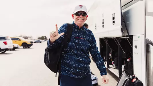 Wes Kittley throwing the guns up sign before getting on a bus
