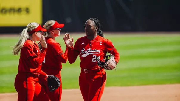 NiJaree Canady high-fiving teammates Mia Williams and Taylor Pannell as she comes off the field