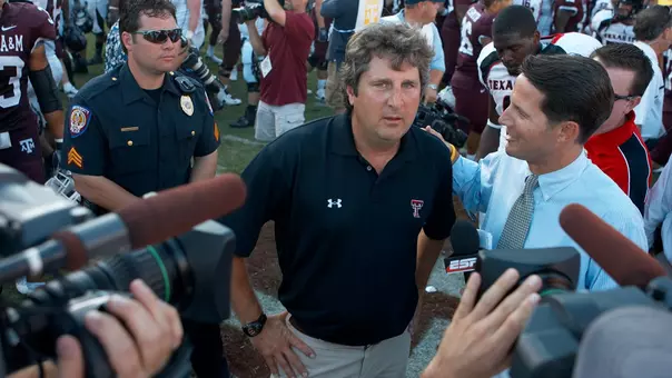 Mike Leach archived photo following a Texas Tech win at Texas A&M with cameras surrounding him postgame.