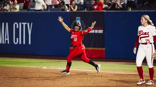 Jasmyn Burns celebrates while running the bases after hitting a home run against Alabama in the Women's College World Series.