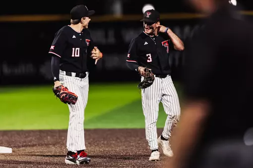 Logan Hughes and Tracer Lopez stand on the field during a pitching change