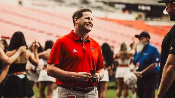 Kirby Hocutt smiles while talking to supporters on the sidelines prior to Texas Tech's 2025 opener versus UAPB.