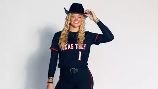 Jayden Heavener holding a cowboy hat on her head for a photo while on a recruiting visit