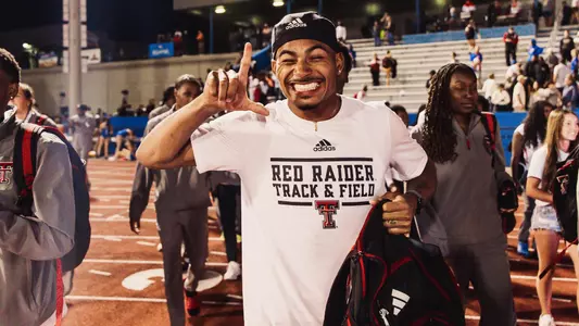 Sincere Rhea throwing up the guns up sign at the Big 12 Outdoor Championships