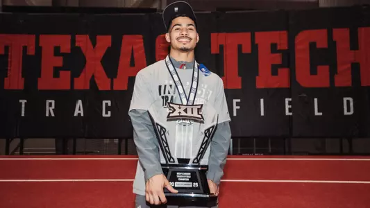 Sincere Rhea holding up the Big 12 Indoor trophy