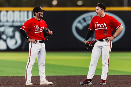 Logan Hughes (right) and Tracer Lopez (Left) stand on the field during a pitching change against BYU