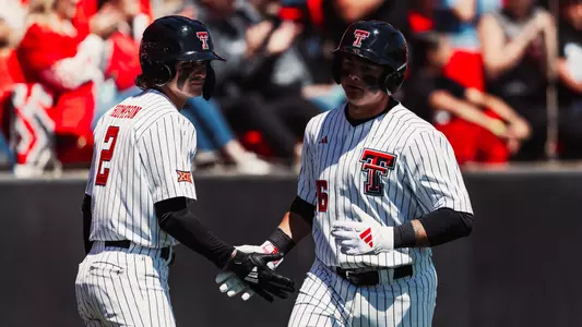 Matt Quintanar (26) and Kyeler Thompson (2) exchange a handshake during the Red Raiders Apr. 4 contest against Houston