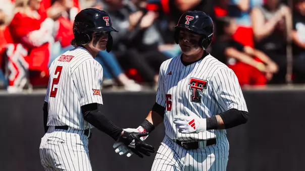 Matt Quintanar (26) and Kyeler Thompson (2) exchange a handshake during the Red Raiders Apr. 4 contest against Houston