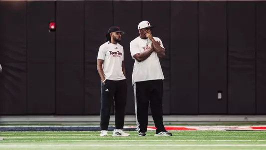 Brian Nance and Freddie Johnson watching practice at Texas Tech fall camp
