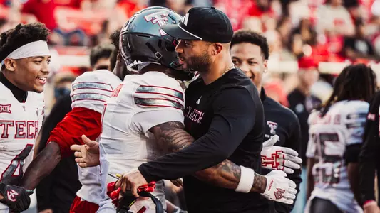 Justin Johnson and Micah Hudson embracing after a play during a spring football game