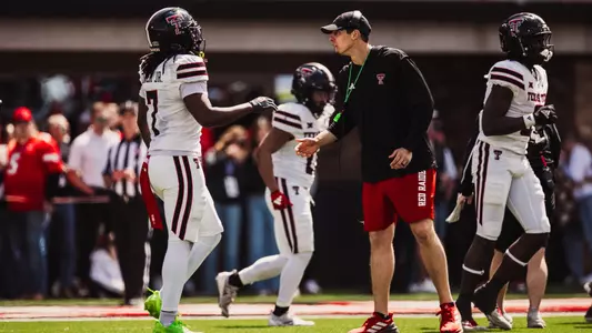 Josh Cochran and Terrance Carter Jr. high-fiving after a drive in a spring game