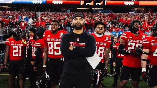 Brandon Stevenson standing in front of football players at the Big 12 Championship game.