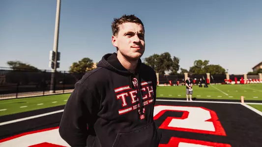 Sean Kenney standing in the middle of the frame at the Texas Tech Football outdoor practice field