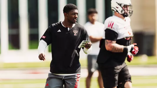 Xavier White holding a playsheet during a football practice session