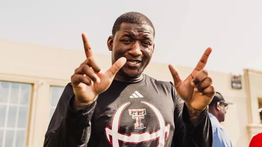 Brian Nance hold the Guns Up sign with both hands