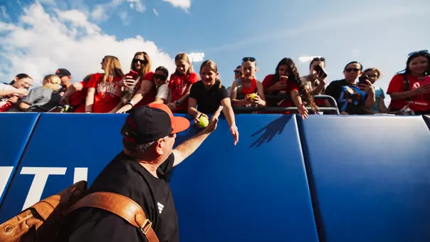 Gerry Glasco high-fiving fans as we walks onto the field at the WCWS