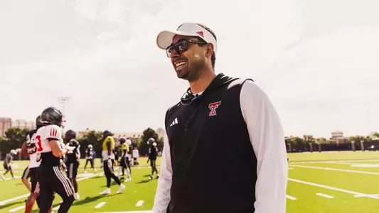 Roger Lira smiling while overseeing football practice