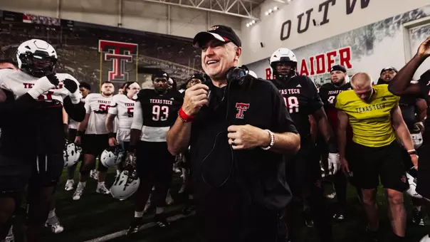 Joey McGuire smiles in the middle of a team huddle during one of Texas Tech's preseason practices.