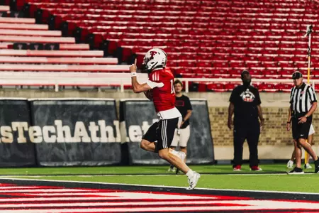 Cannon runs towards his teammate in the end zone to celebrate a touchdown.