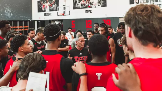 Texas Tech basketball players and coaches gather together before the start of practice.