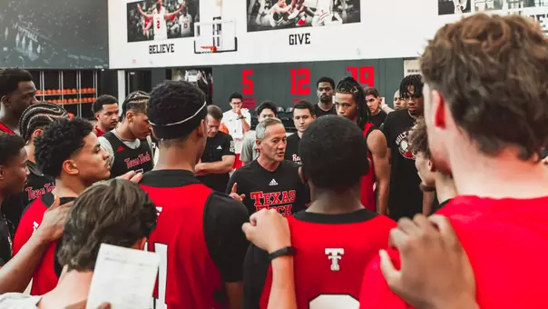 Texas Tech basketball players and coaches gather together before the start of practice.