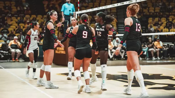Volleyball team huddling up after a point against Wyoming