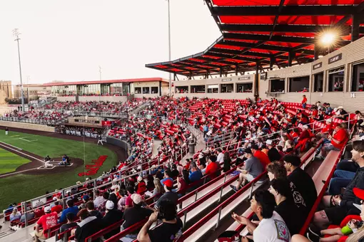 The sun dips lower in the sky at Rip Griffin Park during a 2026 crowd shot from the stands during a baseball game