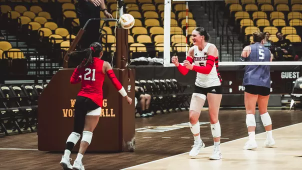 Elia Dinsmore and Emily Contreras celebrating a point for Texas Tech against St. Thomas