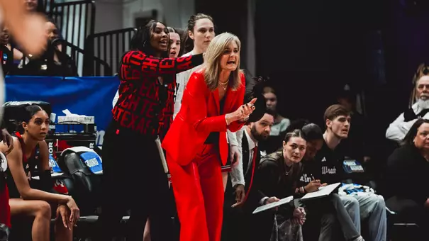 Gerlich standts sideline at the NCAA Tournament clapping