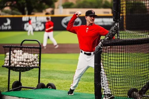 Texas Tech Baseball Coach Tim Tadlock tosses a pitch during batting practice prior to a game against BYU