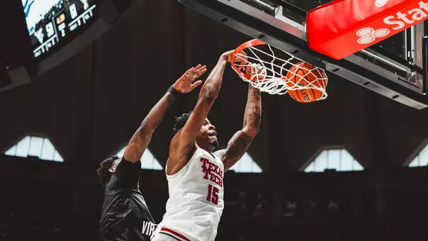 JT Toppin throws down a dunk on a West Virginia defender.