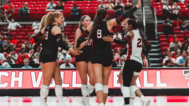 Texas Tech volleyball hudlles up after a point