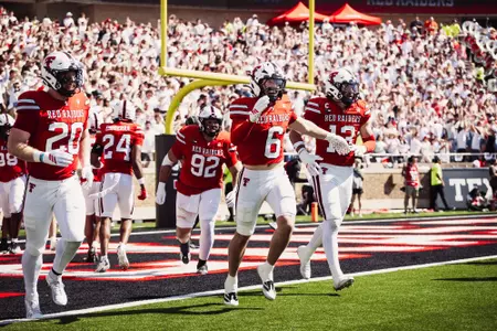 Texas Tech's defense celebrates Austin Romaine's interception return for a touchdown