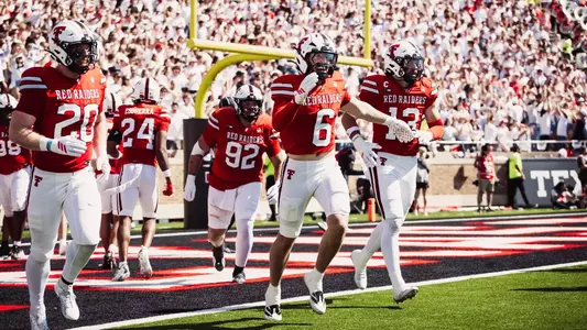 Texas Tech's defense celebrates Austin Romaine's interception return for a touchdown