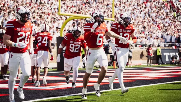 Texas Tech's defense celebrates Austin Romaine's interception return for a touchdown