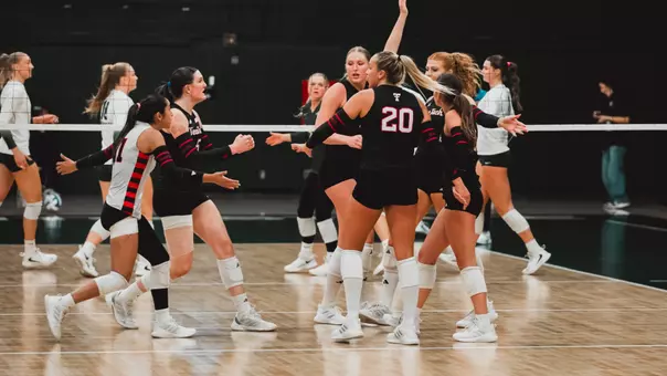 Red Raider volleyball players huddling up after a point against Sacramento State