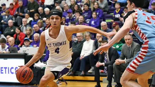 Anders Nelson (4) drives to the basket for Tommie Basketball
