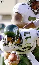 Tulane quarterback J.P. Losman tries to escape from East Carolina's Derek Helms in Saturday's game.