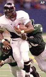 Cincinnati running back Ray Jackson is brought down by Tulane defensive back Quentin Brown and linebacker Jerry Phillips.