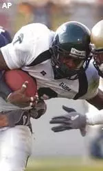 Navy defenders try and tackle Mewelde Moore as he rumbles down the field.